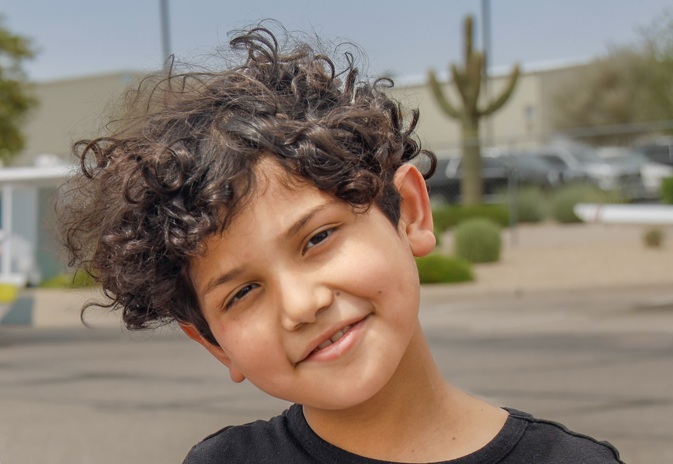 Adan leaning head with cactus in background