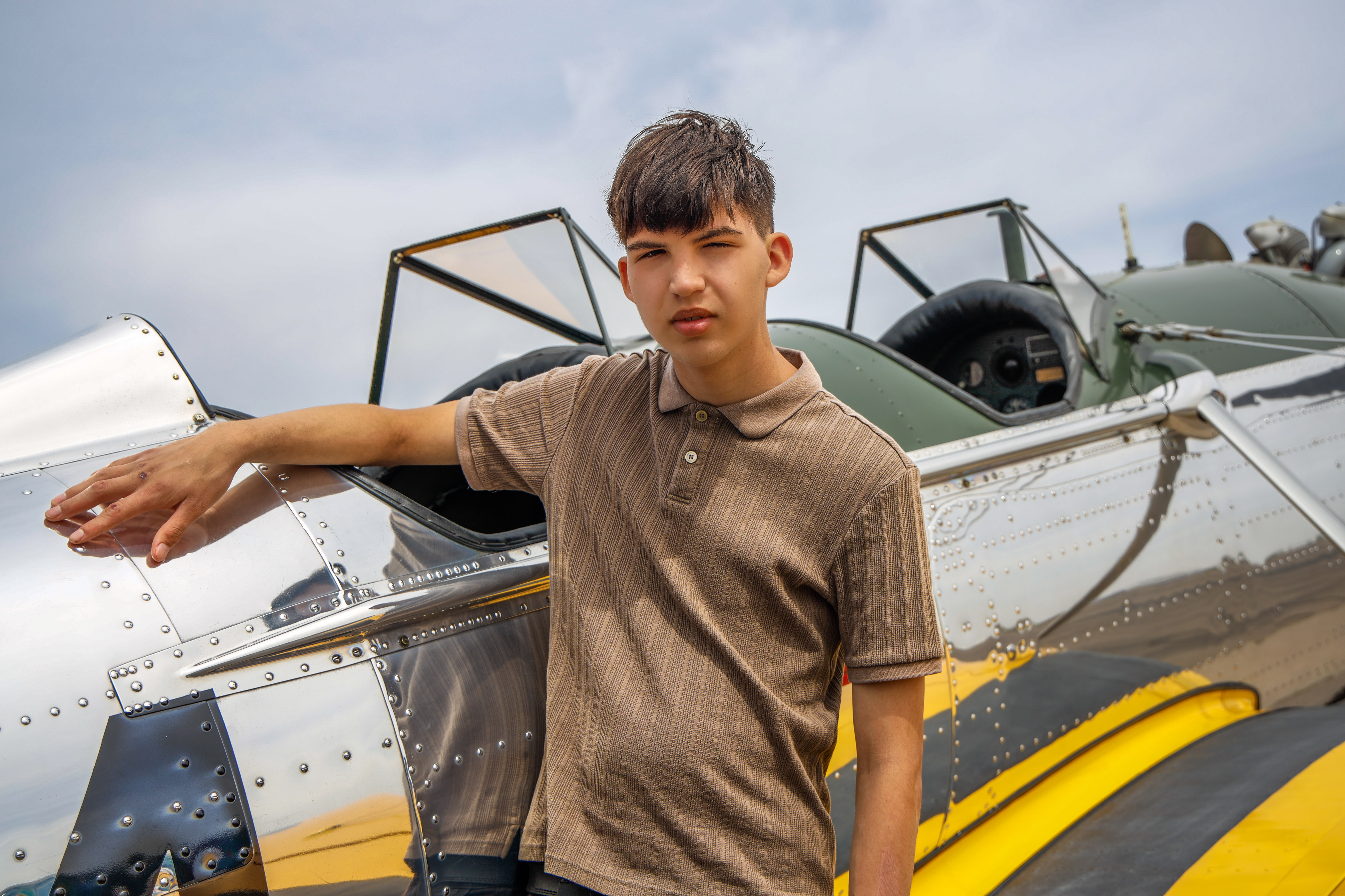 Alexander (3) standing next to chrome and yellow plane