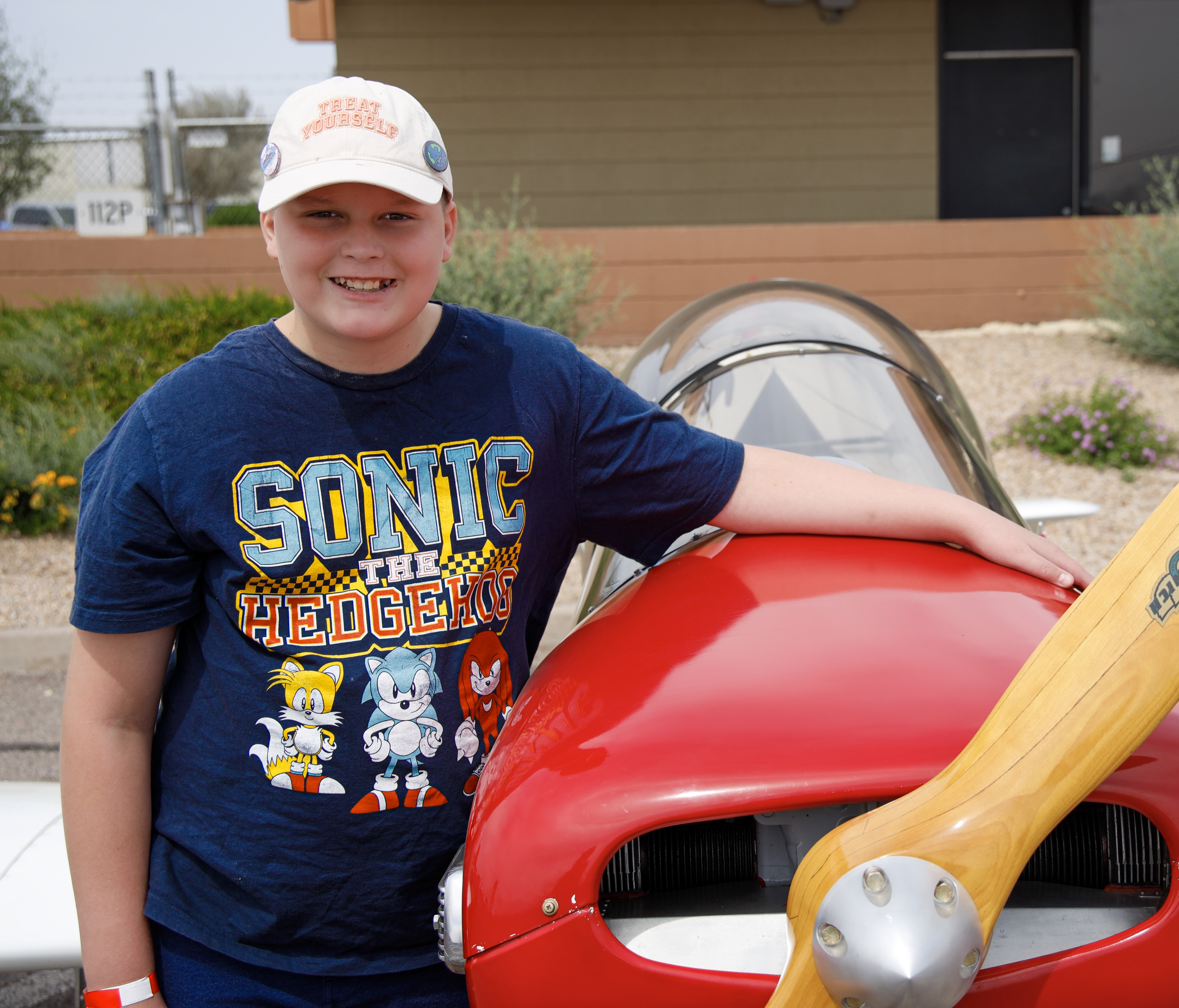 Blake standing next to red plane smiling