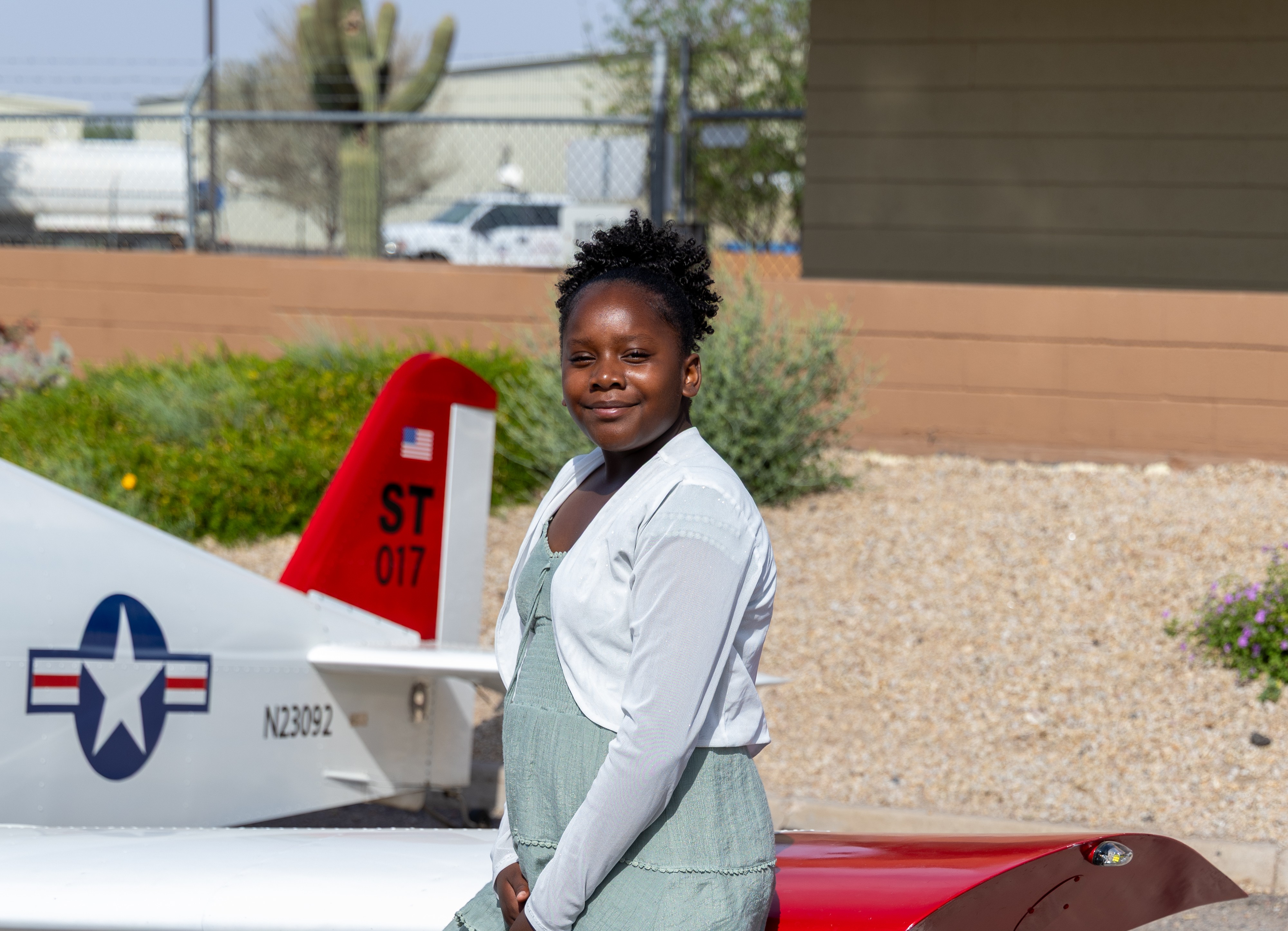 Callie smiling next to plane
