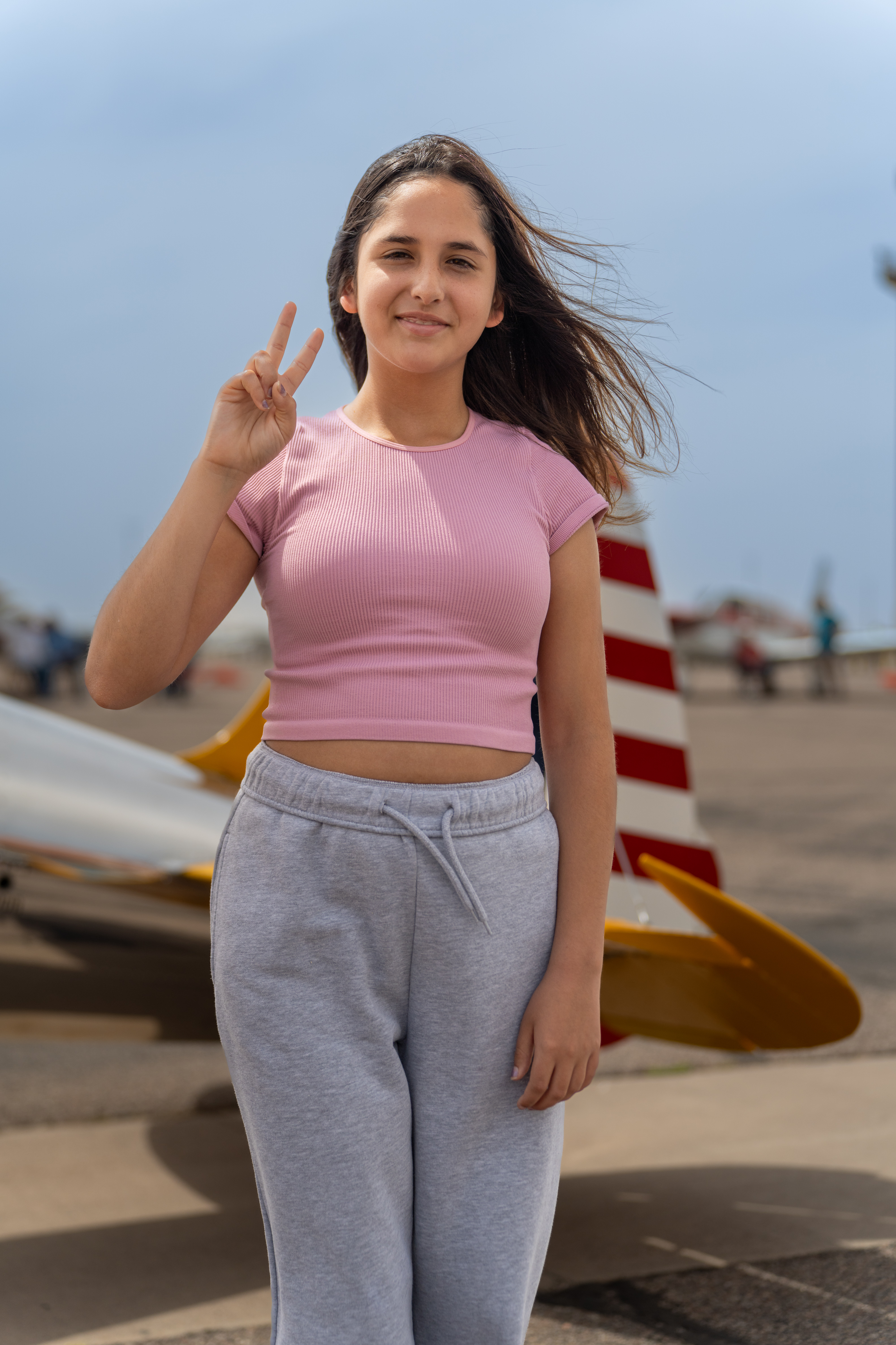 Cecilia standing with plane in background 