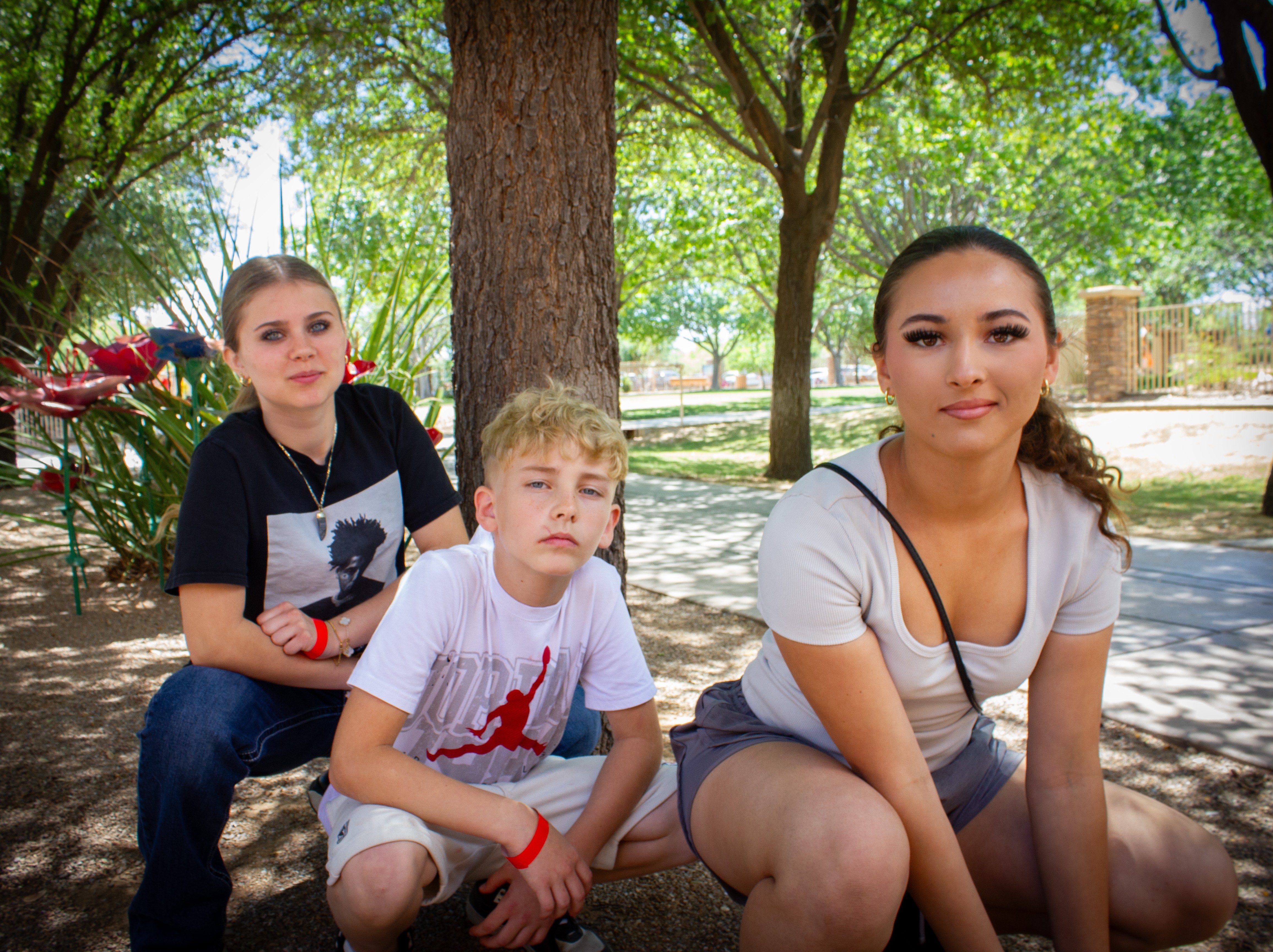 Amiya, Mayra, and Wyatt kneeling by tree