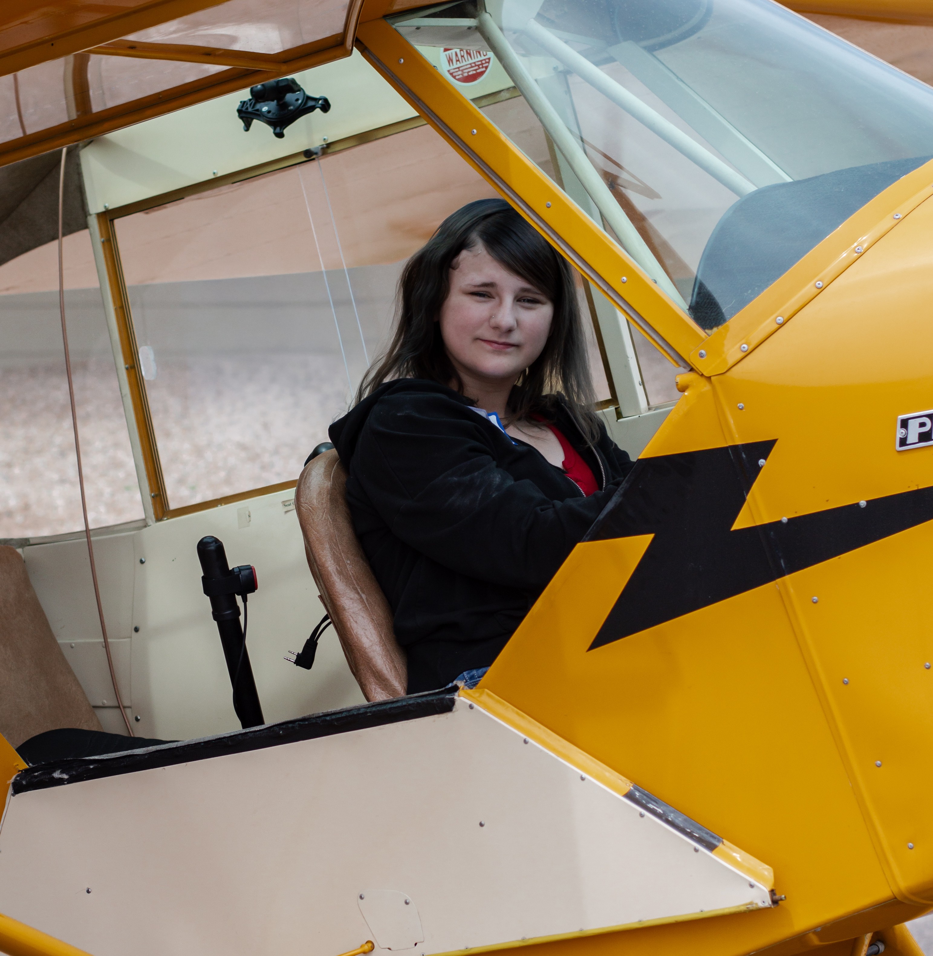 Kaylyn sitting in yellow plane