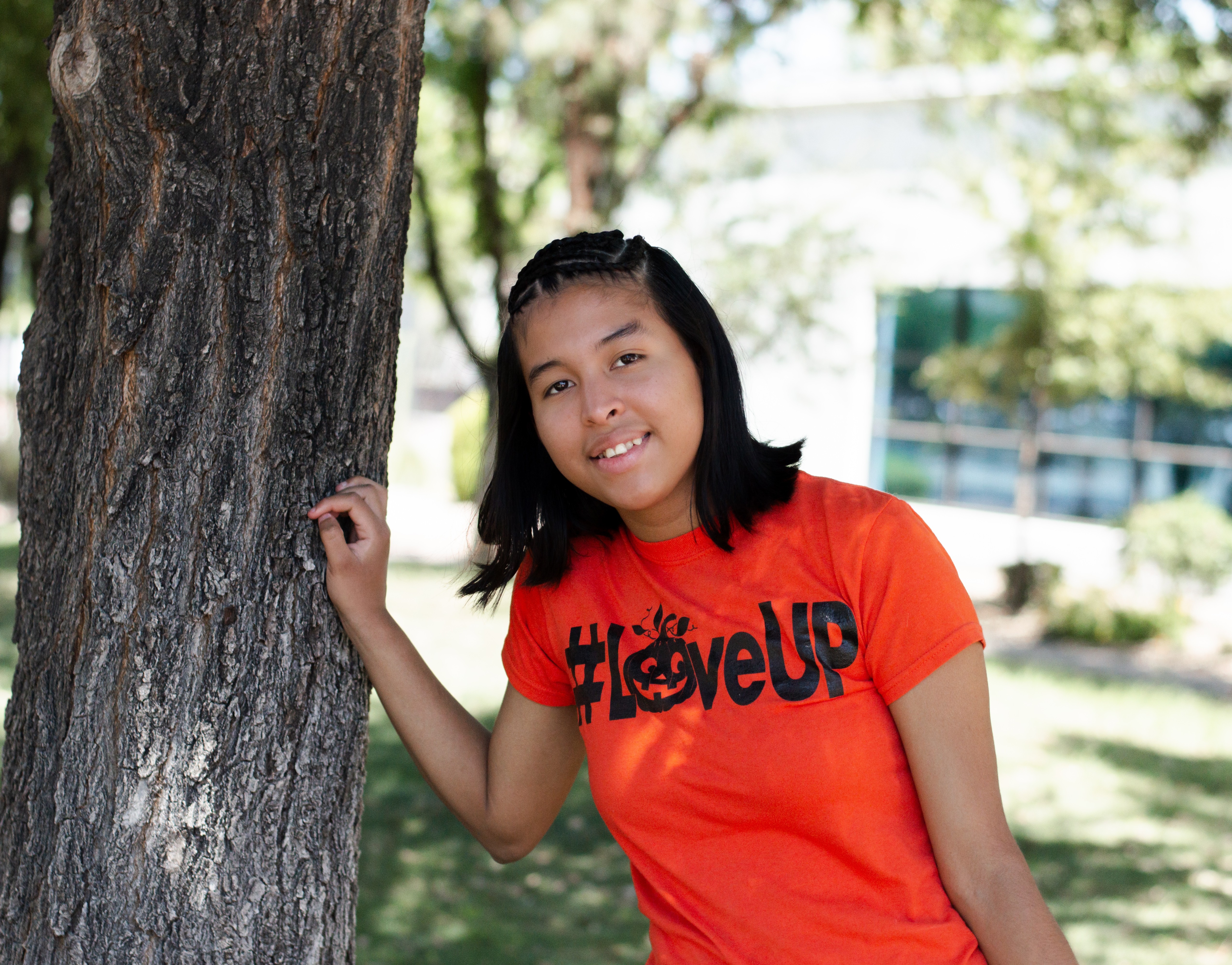 Lizbeth leaning on tree