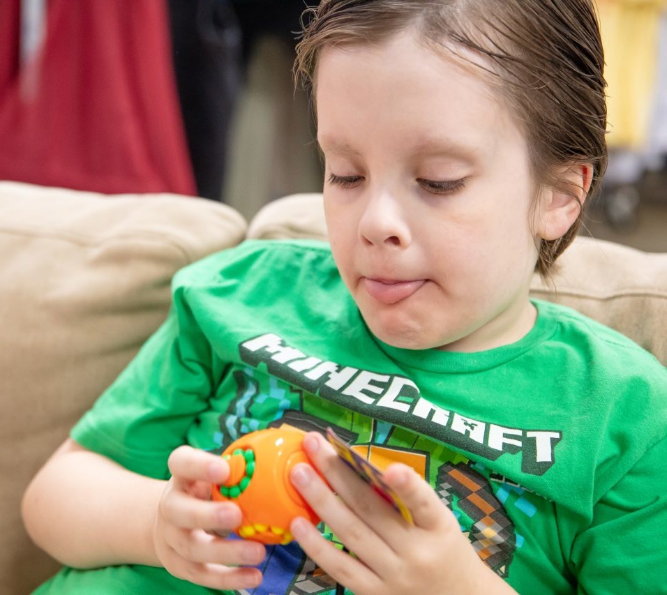 Roy playing with toy with tongue out