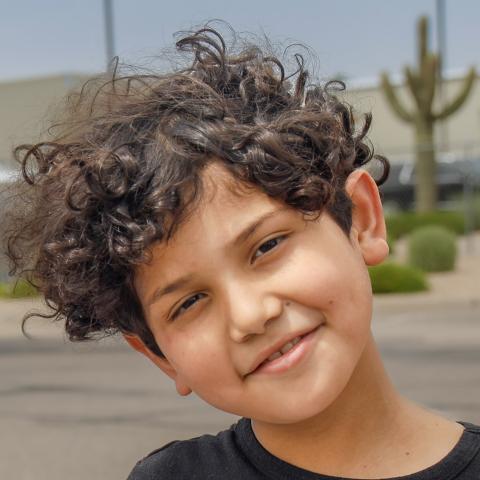 Adan leaning head with cactus in background