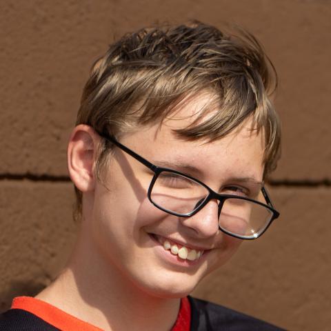 Kolby smiling brown background
