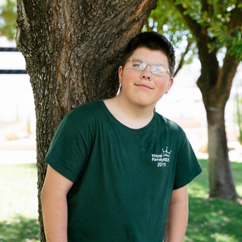 Julyus standing by tree smiling