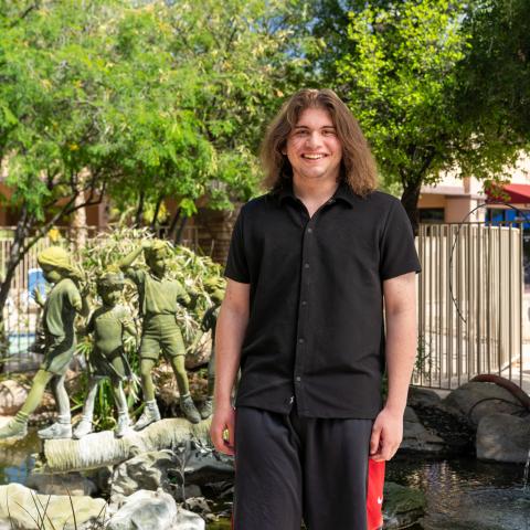 Nathan standing by water and trees
