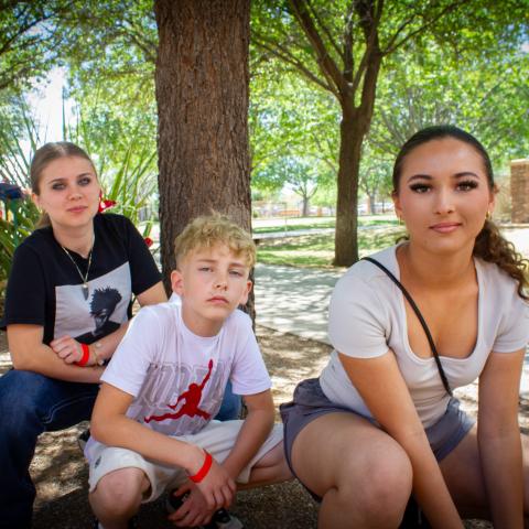 Amiya, Mayra, and Wyatt kneeling by tree