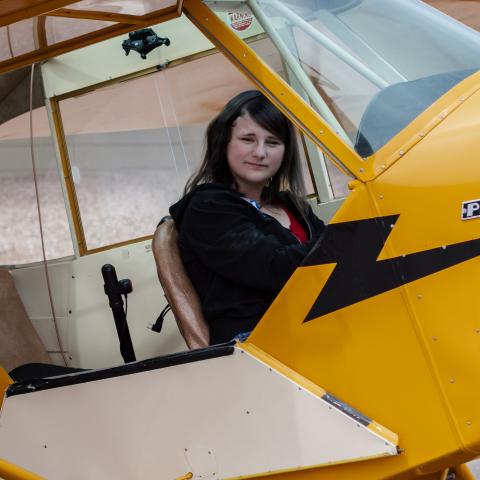 Kaylyn sitting in yellow plane